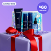 A set of four Curology products standing in front of a Holiday-exclusive Holographic Gift Bag on top of a box wrapped in purple paper with red ribbon against a purple background. The products included are the Gentle Cleanser, Hydro+ Hydration Serum, Brightening Vitamin C Serum, and Daily Moisturizing Lotion Broad Spectrum SPF 30.