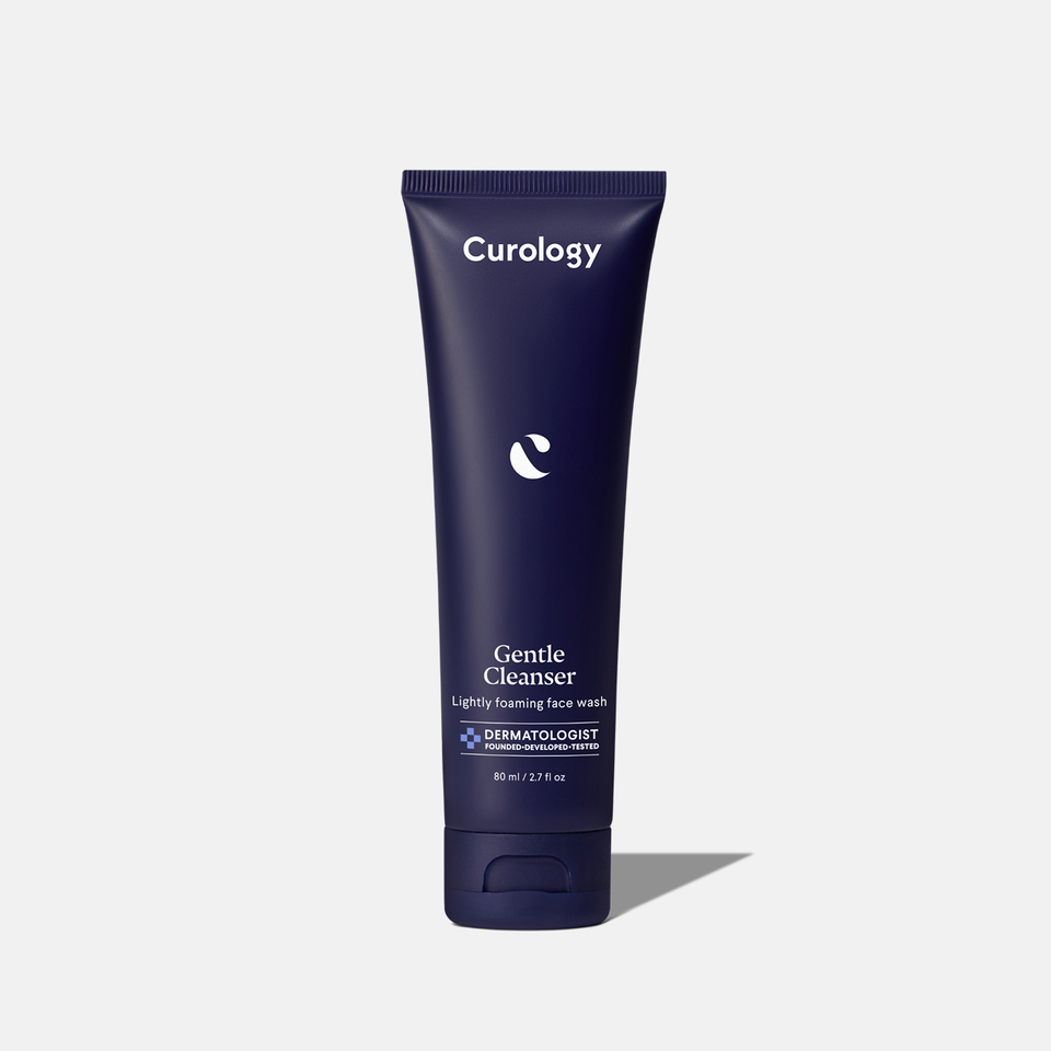 Curology Gentle Cleanser in a dark blue squeeze tube with flip-top cap, labeled ‘Lightly foaming face wash,’ dermatologist founded, developed, and tested.